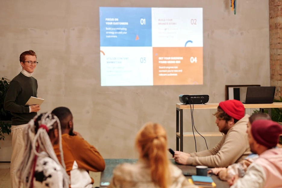 Osoba si zapisuje marketingové nápady do zápisníku v kavárně.